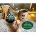 This image shows the battery-operated candle included in your purchase. The candle lights up the carved elf face and has a timer setting.